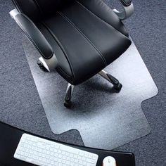 an office chair sitting on top of a desk next to a keyboard and mouse pad