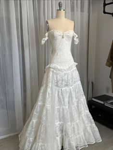 a white wedding dress is on display in front of a mannequin's dummy