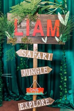 a wooden sign that says safari jungle one explore and the words lama above it are arrows pointing in different directions