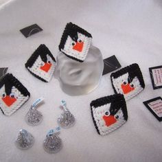 there are several pieces of crocheted penguin decorations on the table with tags around them