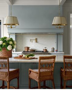 a kitchen with blue cabinets and wicker chairs