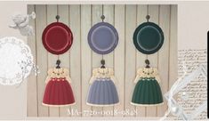 three different colored dresses hanging on hooks in front of a wooden wall with writing underneath