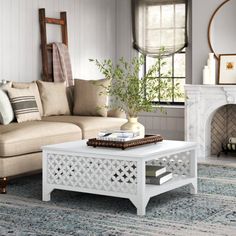 a living room with a couch, coffee table and mirror on the wall above it