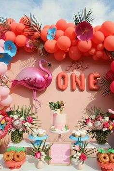 a flamingo themed birthday party with donuts, cake and balloons on the wall