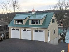 a two story garage with a green roof