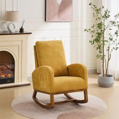 a yellow rocking chair sitting in front of a fire place next to a potted plant