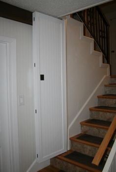 an open door leading up to a set of stairs in a house with white walls and wood steps