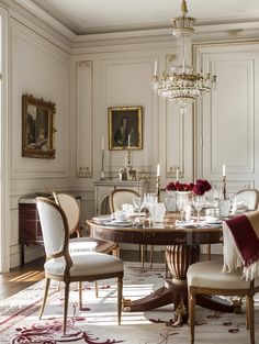 an elegant dining room with chandelier, chairs and table in the middle of the room