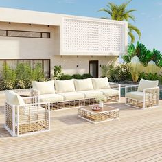 an outdoor living area with white furniture and palm trees in the backgroung