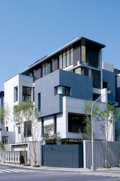 an apartment building with many windows and balconies on the top floor, next to a street