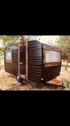 a small black trailer is parked in the grass