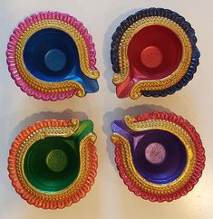 four different colored dishes sitting on top of a table