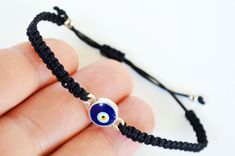 This evil eye bracelet is totally handmade in Turkey - Istanbul. Silver-plated evil eye are localized in the middle. It is black macramé which made by handmade and it is adjustable. Since it is adjustable, it is suitable for everyone. Meaning of Evil Eye : People can knowingly wish negative thoughts on you, but the power of the evil eye is that some people unknowingly and innocently cast the curse on others. That's why it's important to wear an evil eye symbol somewhere on your body or to have i Handmade Black Evil Eye Bracelet For Friendship, Black Evil Eye Bracelet With Sliding Knot As Gift, Adjustable Black Evil Eye Bracelet, Black String Bracelet, Black Evil Eye, Black Macrame, Eye Symbol, Turkish Evil Eye, Turkey Istanbul