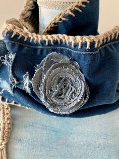 a blue jean jacket with a rose on the side and tassels attached to it