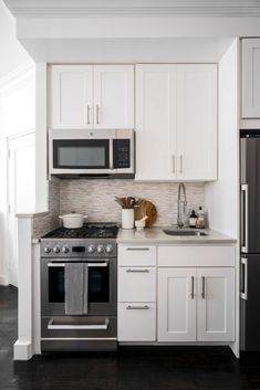 a kitchen with white cabinets and stainless steel appliances