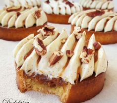 several pieces of bread with white frosting and nuts on top