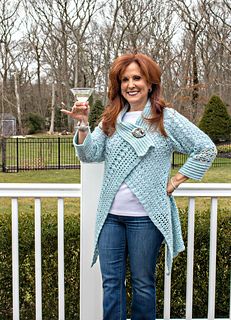 a woman standing on top of a white fence holding a glass in one hand and smiling at the camera