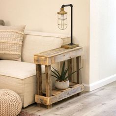 a living room with a couch, table and potted plant on the floor next to it