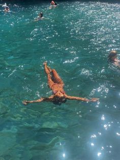 people are swimming in the clear blue water