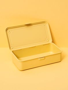 an empty yellow lunch box sitting on top of a table