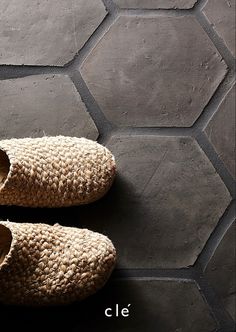 a pair of slippers sitting on top of a tiled floor