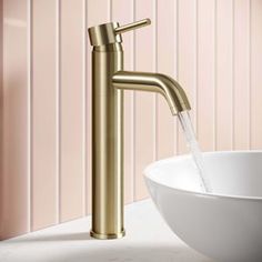 a bathroom sink with a gold faucet and white bowl