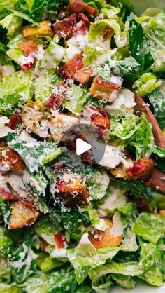 a salad with bacon, lettuce and cheese on it in a white bowl