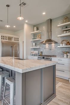 a large kitchen with an island and bar stools