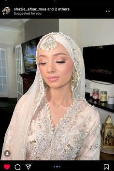 a woman wearing a white veil and headpiece in a living room with a television