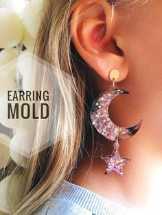 a woman wearing earrings with stars and moon design