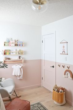 a baby's room with pink and white walls