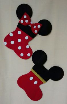 two mickey and minnie mouse christmas stockings on a white sheet with polka dot designs, one red and the other black