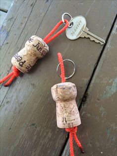 two wine corks tied together with red string and keychain on wooden table