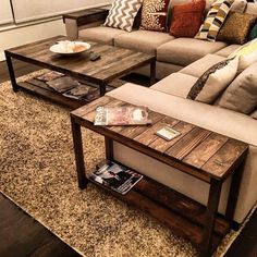 a living room with couches, tables and pillows on the floor in front of a window