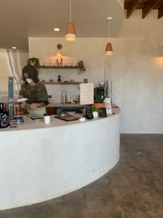 a woman standing behind a counter in a restaurant