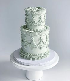 a three tiered cake sitting on top of a white table next to a plate