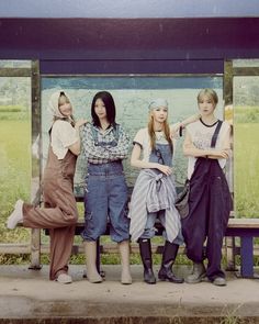 four young women are sitting on a bench