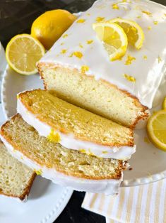 slices of lemon pound cake on white plates with sliced lemons around the edges and one slice cut off