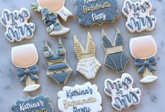 decorated cookies are arranged on a marble countertop with the names of their guests and date