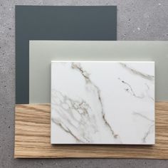 two different colors of marble on top of each other with wood in the bottom corner