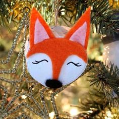 an ornament shaped like a fox hanging from a christmas tree with eyes closed