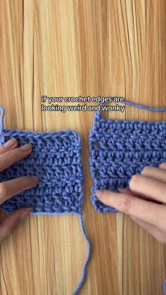 two hands are crocheting together to make a square with yarn on the table