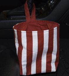 a red and white striped bag sitting on top of a car seat