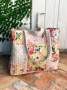 a purse sitting on the ground next to a plant