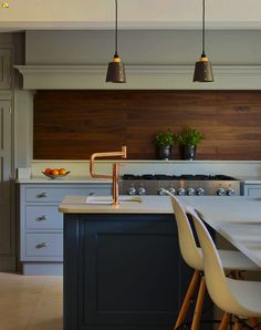 a kitchen with an island, stove and chairs