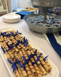 an assortment of food on a table with blue ribbon around the edges and plates in the background