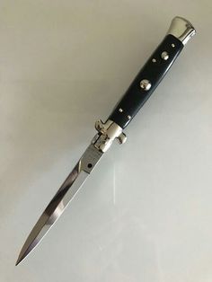 a knife that is sitting on top of a white surface with the blade still attached to it