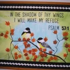 two birds sitting on a tree branch with the words in the shadow of thy wings i will make my refuge