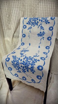 a blue and white chair sitting on top of a bed