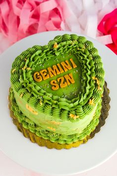 a heart shaped cake with the words gummy san on it sitting on a plate